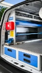 02_Linke Wand im Ford Custom mit ausziehbarem Schraubstockhalter, Kofferfixierung, Regalwanne und durchsichtigen Schubladen