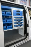 05_Außenansicht der rechten Tür mit Koffern, Schubladen, Sichtlagerkästen im Transporter