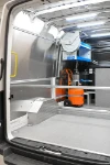 Avvolgitubo e compressore fissati alla parete del MAN TGE
